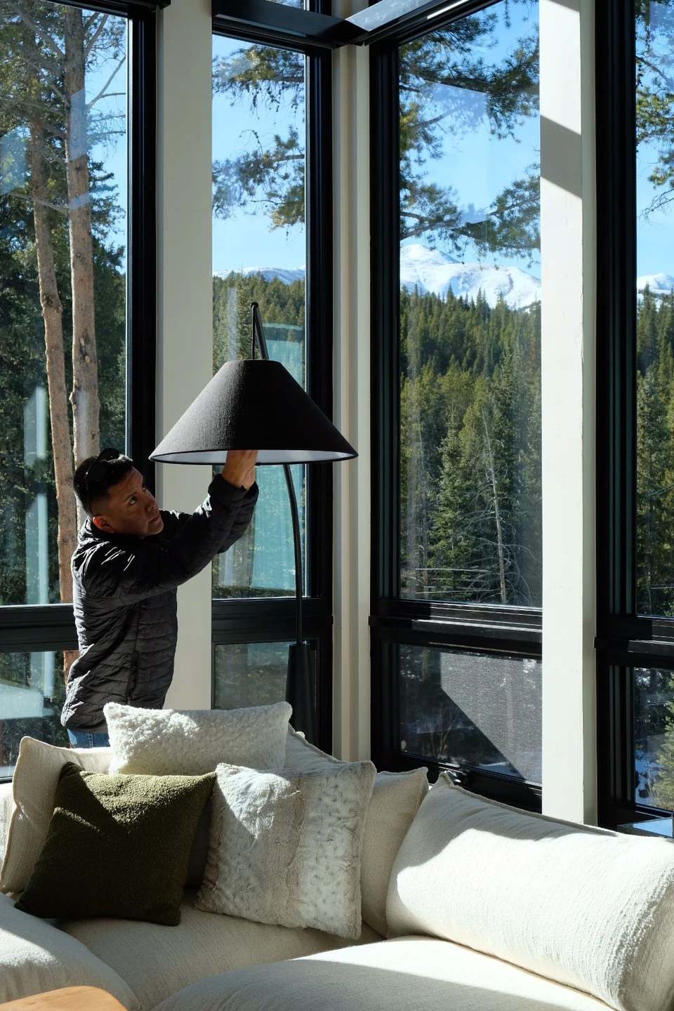 Team member tending to a floor lamp in a mountain home's living room