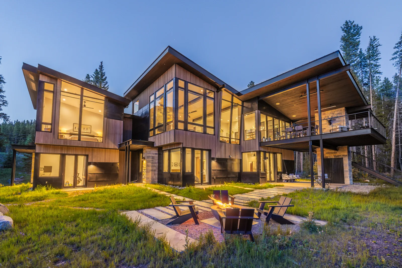 Luxury mountain home with evening fire pit at twilight