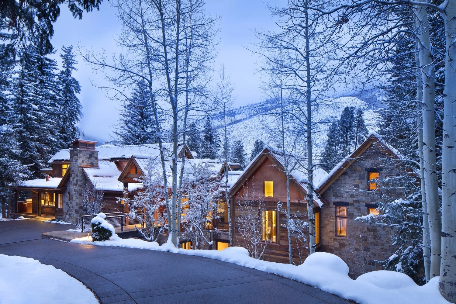 Timber-and-stone home in the Vail Valley surrounded by snow-covered aspens